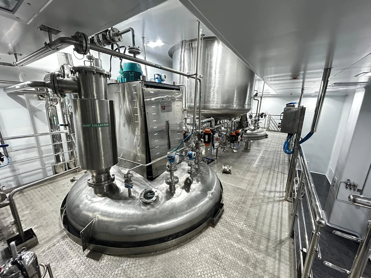 Dust collector and powder handling equipment on the mezzanine of a contained API suite