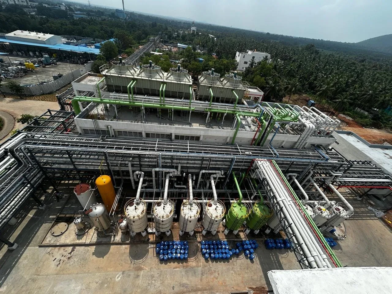Roof-level utilities of an API block: cooling towers, brine and chilled-water headers and the solvent ring main